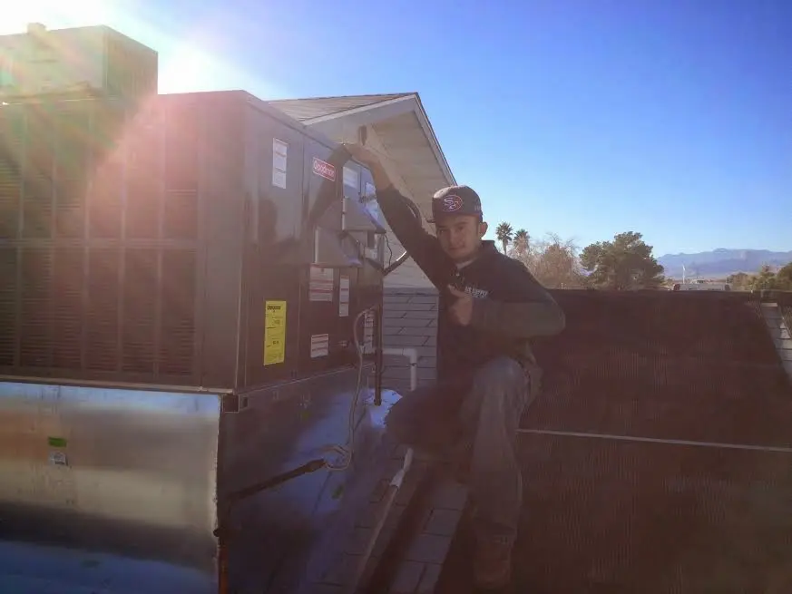 HVAC technician performing AC Tune-Up on a rooftop unit in Escalon